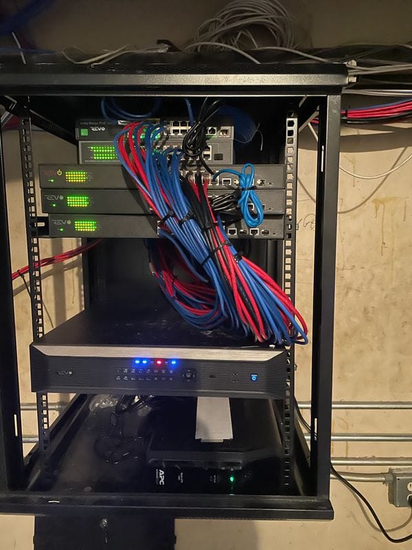 The same rack rebuilt: switches stacked and labeled, red and blue runs combed and tied